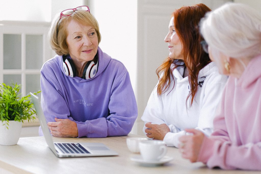 pexels-photo-5257610-5257610 Cheerful aged women in trendy clothes sitting at table with cups of tea and laptop and communicating at home in daytime